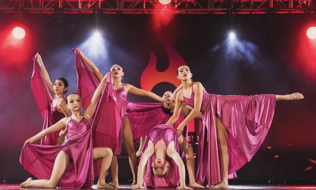 Second Street dancers in magenta costumes performing onstage